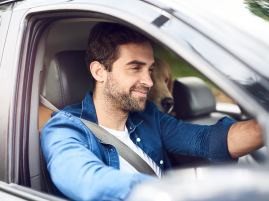 Homem sorrindo enquanto dirige