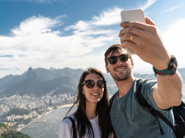 Homem e mulher tirando selfie no topo de uma montanha